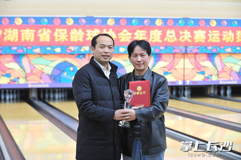 湖南省保龄球协会秘书长唐焕为男单冠军黄晓成（右）颁奖。均为长沙晚报记者 小刘军 摄 