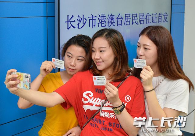 今天，长沙市港澳台居民居住证首发式举行。图为在中南大学求学的三位香港美女领取港澳居民居住证以后高兴地用手机自拍。均为长沙晚报记者 邹麟摄