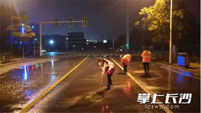深夜，夏利华和同事们应急处理路面污染。