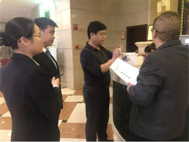 图为陈刚局长对照创建标准检查银天酒店便民医药箱