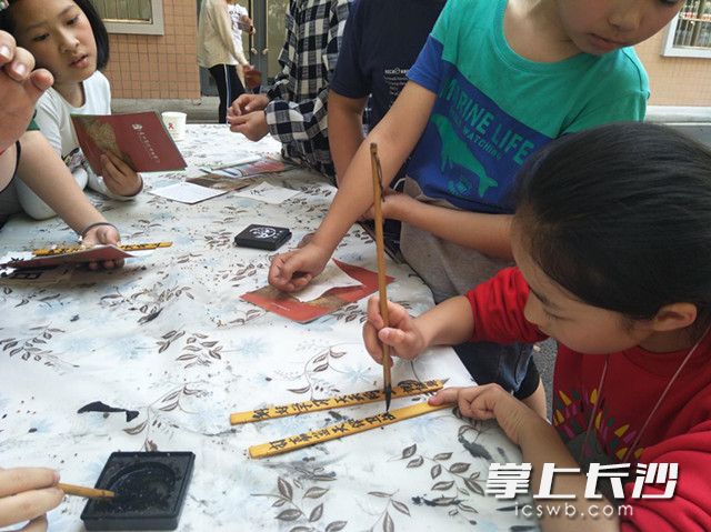 麻园岭小学的学生祝钗乐，提笔在简牍上写下了自己打赢蓝天保卫战的铮言。