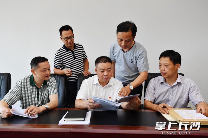 望城区委常委、区纪委书记、区监委主任秦国良（前排中）与同事们一同认真查看办案材料。长沙晚报记者周柏平摄