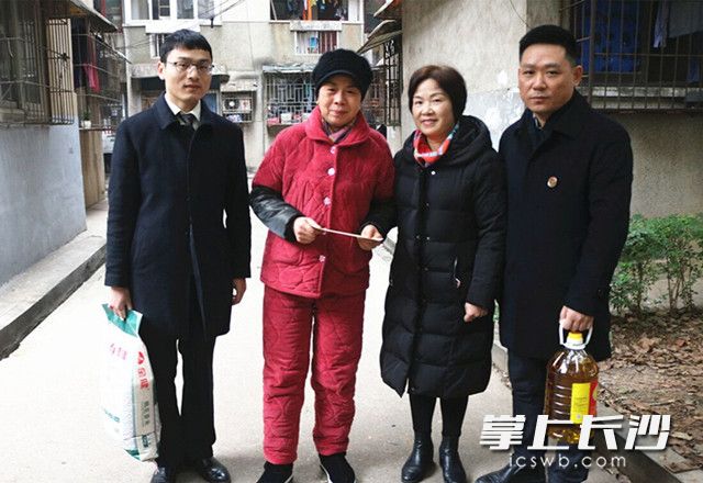 麓山公证处党支部成员给困难居民送上慰问金和物资。