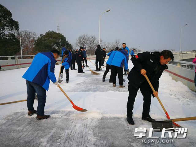 橘子洲工作人员正在清除支桥冰面。