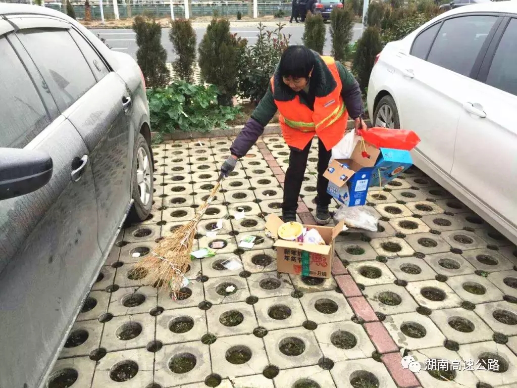 △衡阳管理处常宁服务区工作人员正在打扫被随手扔在停车区域的包装袋、方便面盒子、零食袋等垃圾。