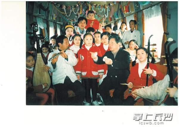 在前往湛江的火车车厢里，小演员们为全体乘务员慰问演出，图中穿黑色衣服的为当年的民乐队指导高炳点老师。