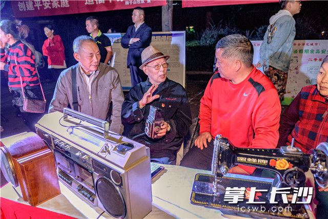 85岁的居民黄国麒如数家珍的给大伙介绍家里这些老“古董”，让大伙感受到沧桑40年大家生活的变迁 。 均为长沙晚报记者 陈飞 摄