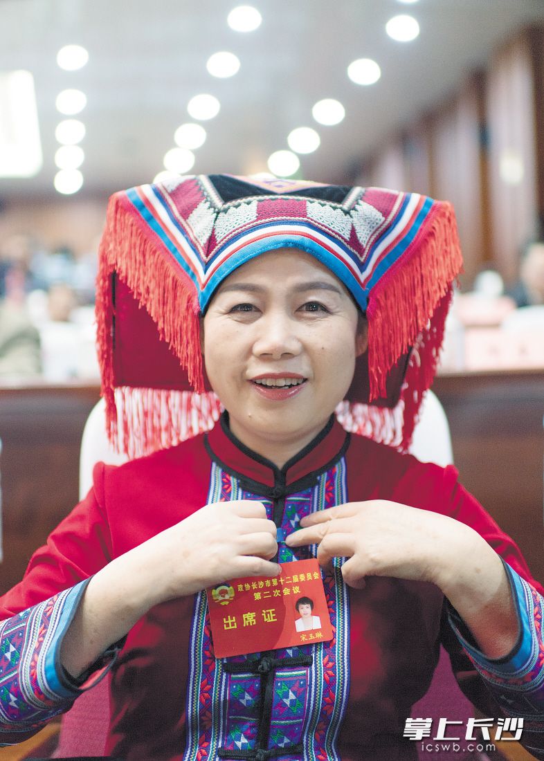 盛装赴会　　闭幕会开始前，着民族服饰的市政协委员宋玉琳整理自己的出席证。