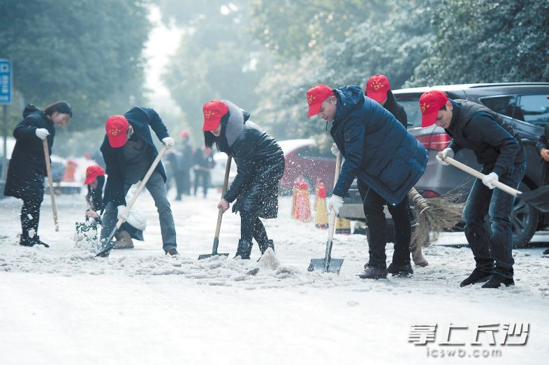 昨日上午，芙蓉广场，长沙市人力资源和社会保障局的志愿者在清理人行道上的积雪。 长沙晚报记者 黄启晴 摄