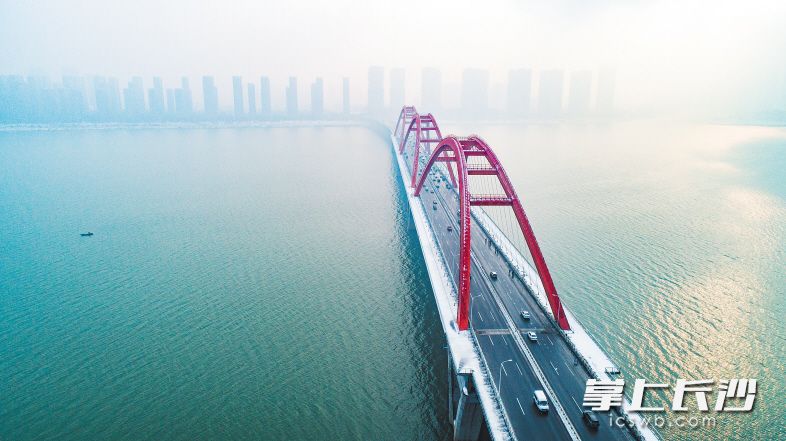 昨日8时30分，福元路大桥车行畅通有序，桥面上黝黑的车道与两边桥栏上的白雪形成鲜明对比。长沙晚报记者 邹麟 摄