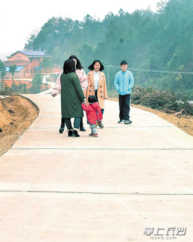 去年，宁乡完成农村公路“双投”项目里程223公里。图为正月初四，白杨湾的村民开心地走在刚修好的水泥路上。长沙晚报记者 贺文兵 摄