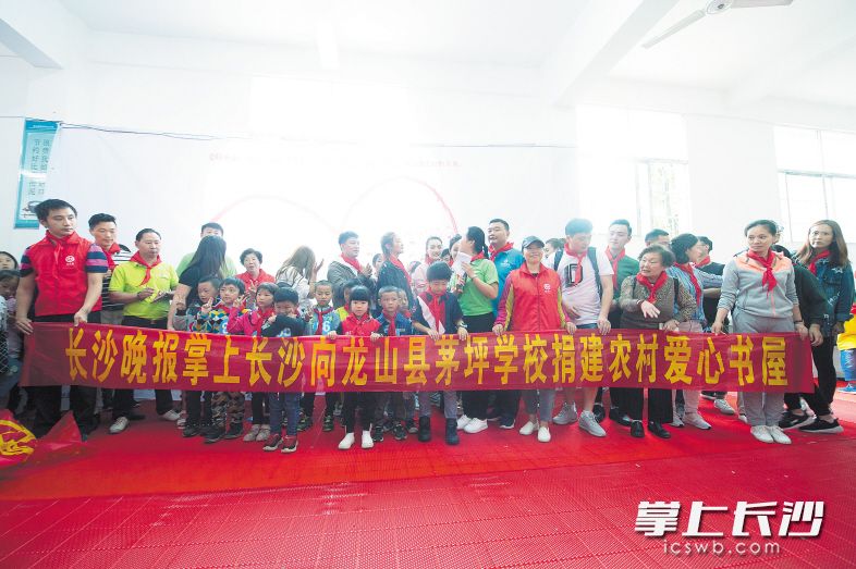 5月31日，长沙晚报掌上长沙、湘爱会联手湖南少儿出版社向龙山县茅坪学校捐赠课外图书共计1400余册，并建立掌上长沙“农村爱心书屋”。 长沙晚报记者 李锋 摄