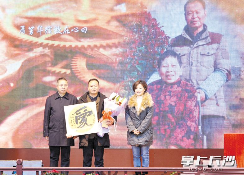 省委宣传部副部长、省文明办主任刘进能（左一）、市委宣传部副部长、市文明办主任郭润葵（右一）为感动中国2017年度人物、中国好人谢海华赠送书法作品。