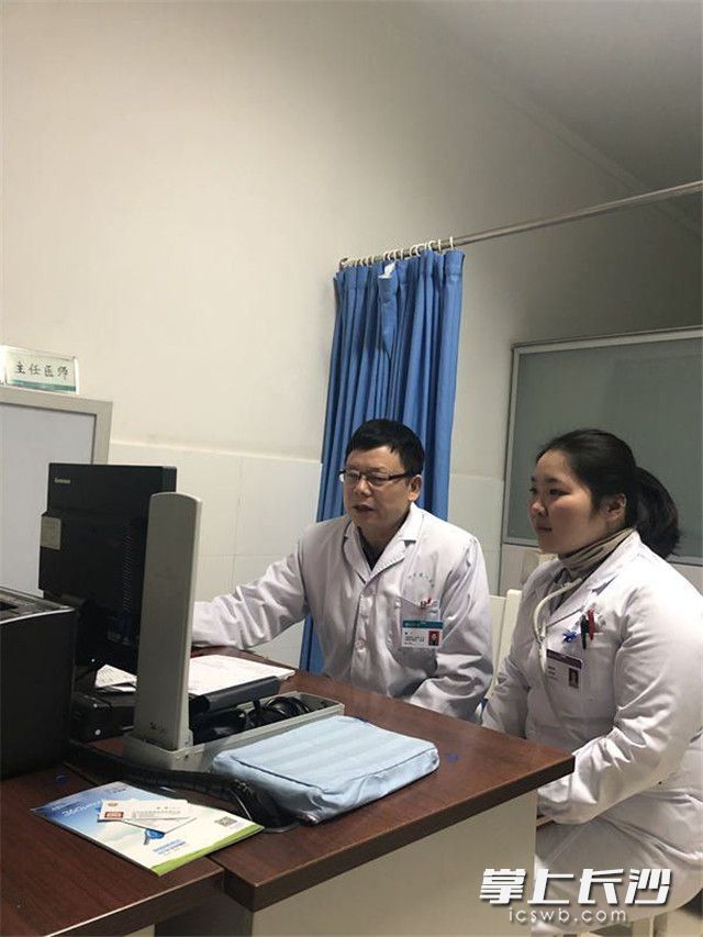 沙市第一医院心内科一病区主任傅广教授（左一）正在帮谭笑阳分析、讲解病例。