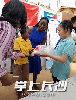 长沙小学生周嘉忆（右）送礼物给塞拉利昂小朋友