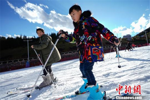 蓝天白云下，游客体验滑雪。贺俊怡　摄