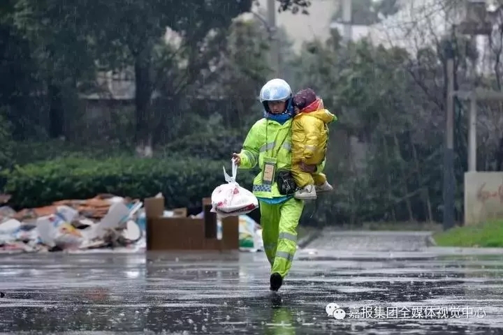 雨中，李帮勇抱着不到三岁的女儿送外卖。