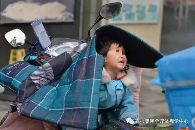 独自坐在电瓶车安全座椅上的女儿从睡梦中醒来，哭了起来。