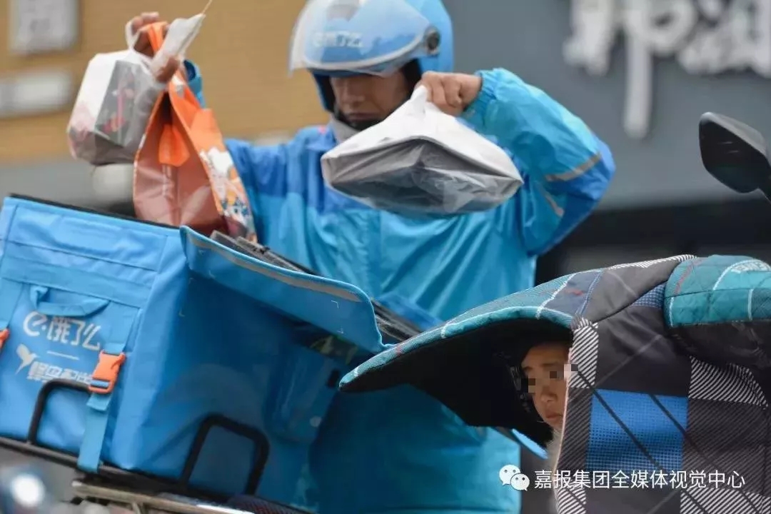 李帮勇把电瓶车停在路边，从保温箱拿出外卖。