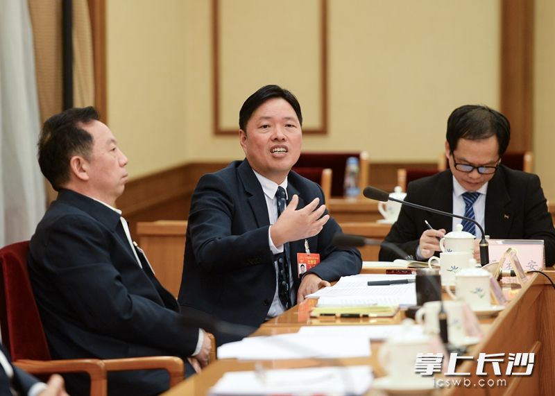 3月7日，全国人大代表、步步高集团董事长王填（中）在会上提相关建议。通讯员 冉新娜