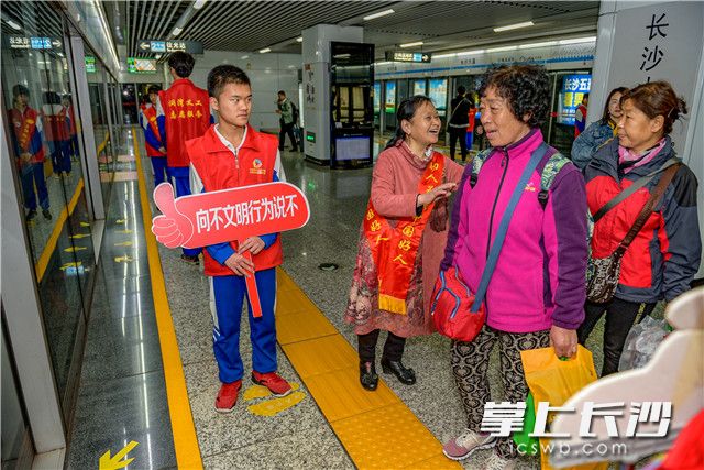 中国好人代表,圭塘社区义工孙建华携手雨花区20余名学生志愿者,手持文明引导牌,热情引导地铁乘客有序排队。 均为全媒体记者 陈飞 摄 中国好人代表,圭塘社区义工孙建华携手雨花区20余名学生志愿者,手持文明引导牌,热情引导地铁乘客有序排队。 均为全媒体记者 陈飞 摄