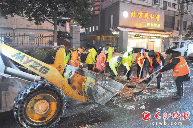 昨夜，一群环卫工人仍奋战在除冰一线。