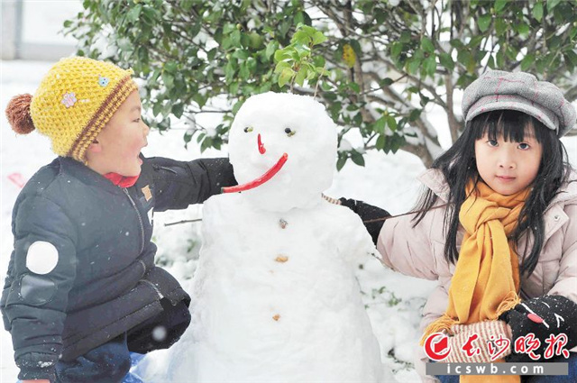 两个孩子在堆雪人。
