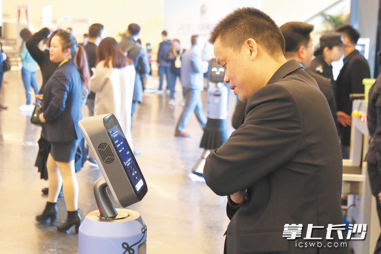 岳麓峰会主会场入场口，智能机器人向参会嘉宾介峰会情况。均为黄荣佳 摄