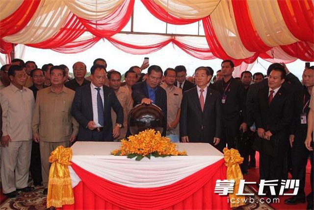 柬埔寨首相洪森按下溢洪道闸门启动按钮。