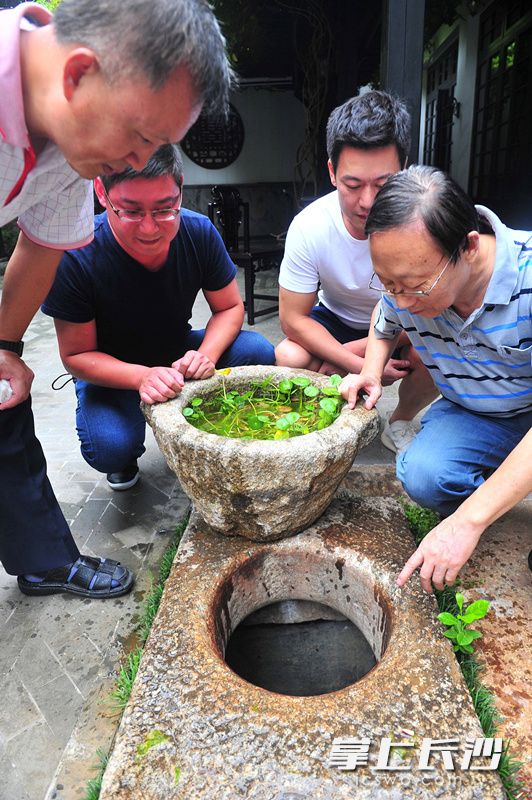 “这是一口至少有300多年历史的古井。”今日，长沙文史专家陈先枢（右一）来到芙蓉区人民西路百果园21号程潜公馆，对院内一口水井观察分析后说。长沙晚报记者 贺文兵 摄
