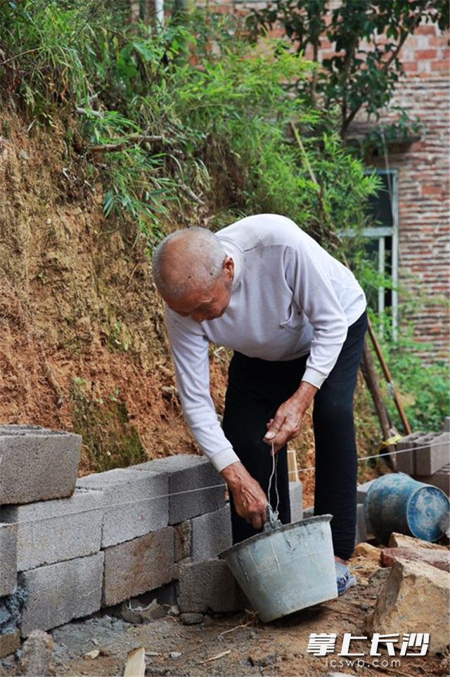 王名清爷爷在砌墙。刘松柏 摄