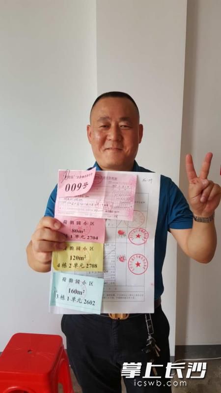 抽签后亮出自己的房号，分房户开心不已。