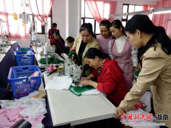 湖南湘绣城集团顺龙服装厂工人放弃休息时间，加班加点，赶制订单。