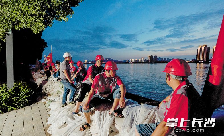▲7月4日晚8时,湘江中路北段,志愿者袁其文和队员们已经连续24小时值守,虽然水位有所下降,仍然不敢有一点放松。