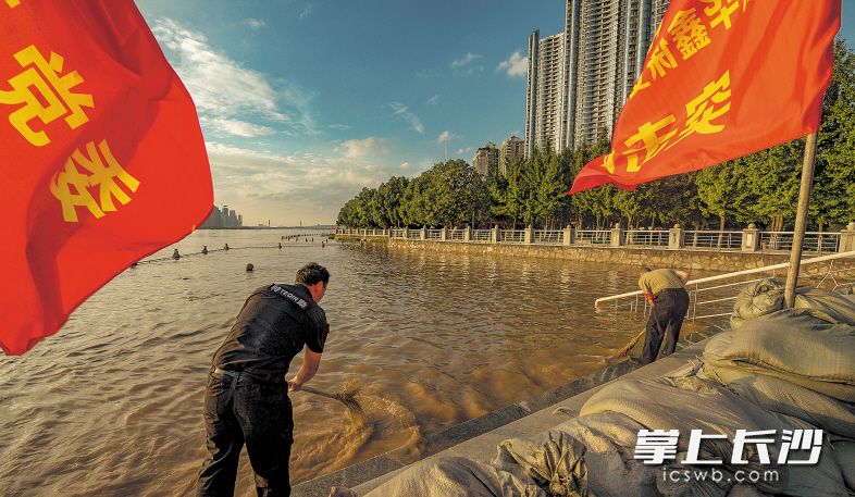 ▲7月4日晚6时,湘江沿岸志愿者在清洗水退后的台阶。