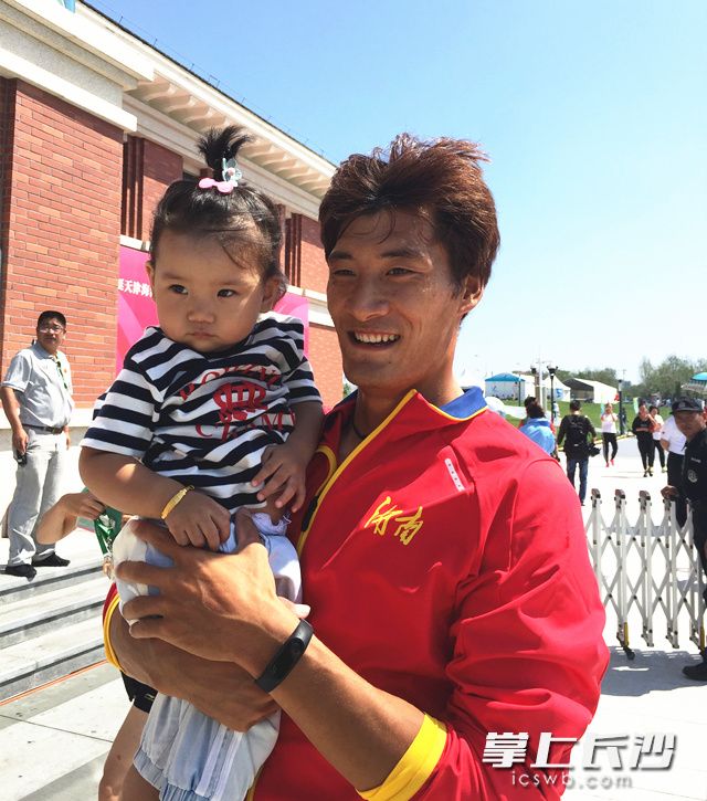 梁明阳夺冠后带着女儿庆祝。