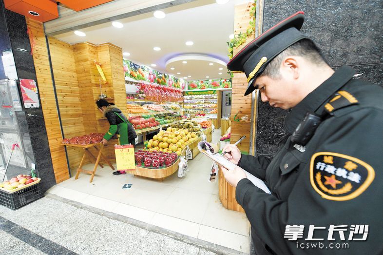 昨日，芙蓉区城管大队马王堆中队对凯旋湾小区一处占道经营的水果店下达整改通知。　　均为长沙晚报记者 黄启晴 摄