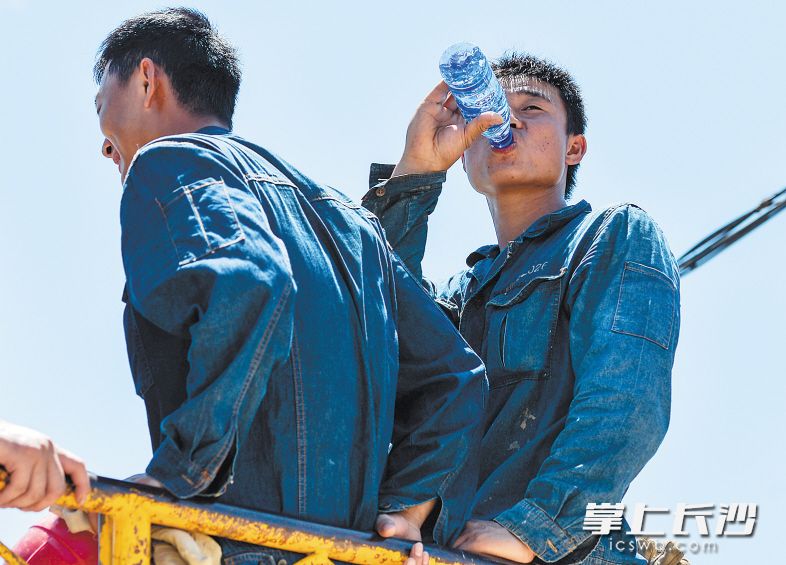 刚从电线杆上下来的供电公司工作人员全身被汗水湿透。　　均为长沙晚报记者 邹麟 摄