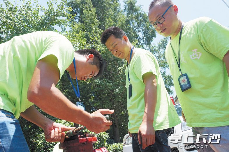 消火栓的日常保养也是他们工作的一部分，滚烫的消火栓通过扳手将热量传递到手上，每每保养完手上都已通红。均为长沙晚报记者 余劭劼 摄