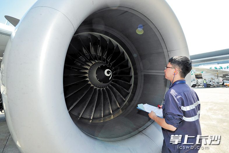 烈日下,张军避无可避,瞪大眼睛,直直盯住发动机运转情况,直到确认内部一切正常。均为长沙晚报记者 王志伟 摄