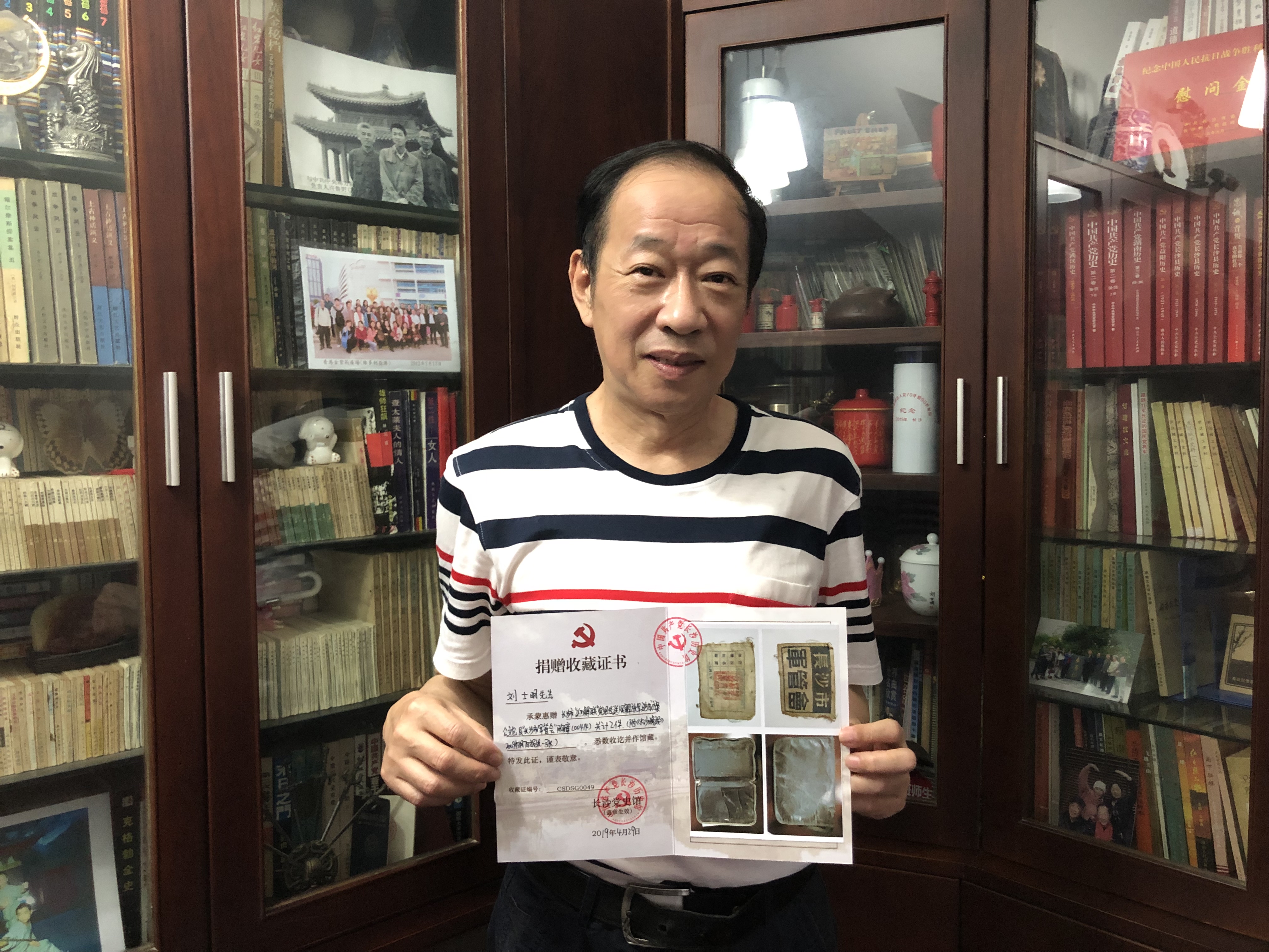 刘士明向记者展示长沙党史馆颁发的收藏证书。 长沙晚报全媒体记者 周游 摄