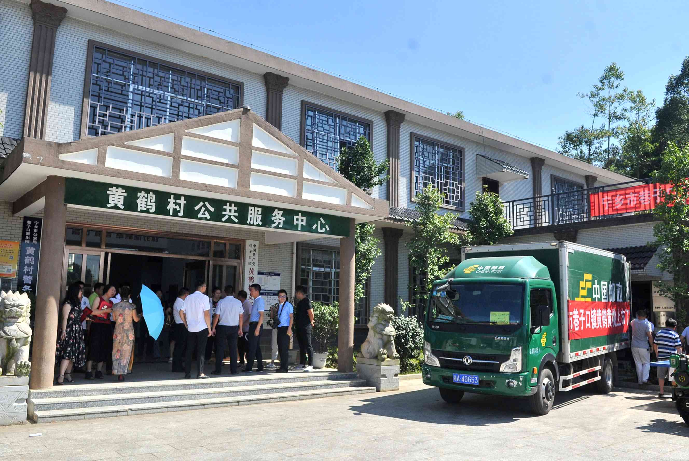 邮政快递车开到了黄鹤村，准备将黄桃运往各地。