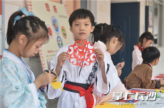 学生现场高兴地展示自己的剪纸作品。