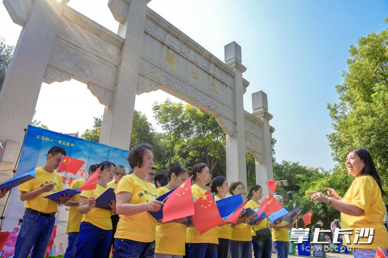 天心阁牌楼下，社区“廉花合唱团”的五老志愿者们为大家带来激情洋溢的歌曲《红袖章之歌》《我和我的祖国》，把现场的气氛一下子就调动起来。