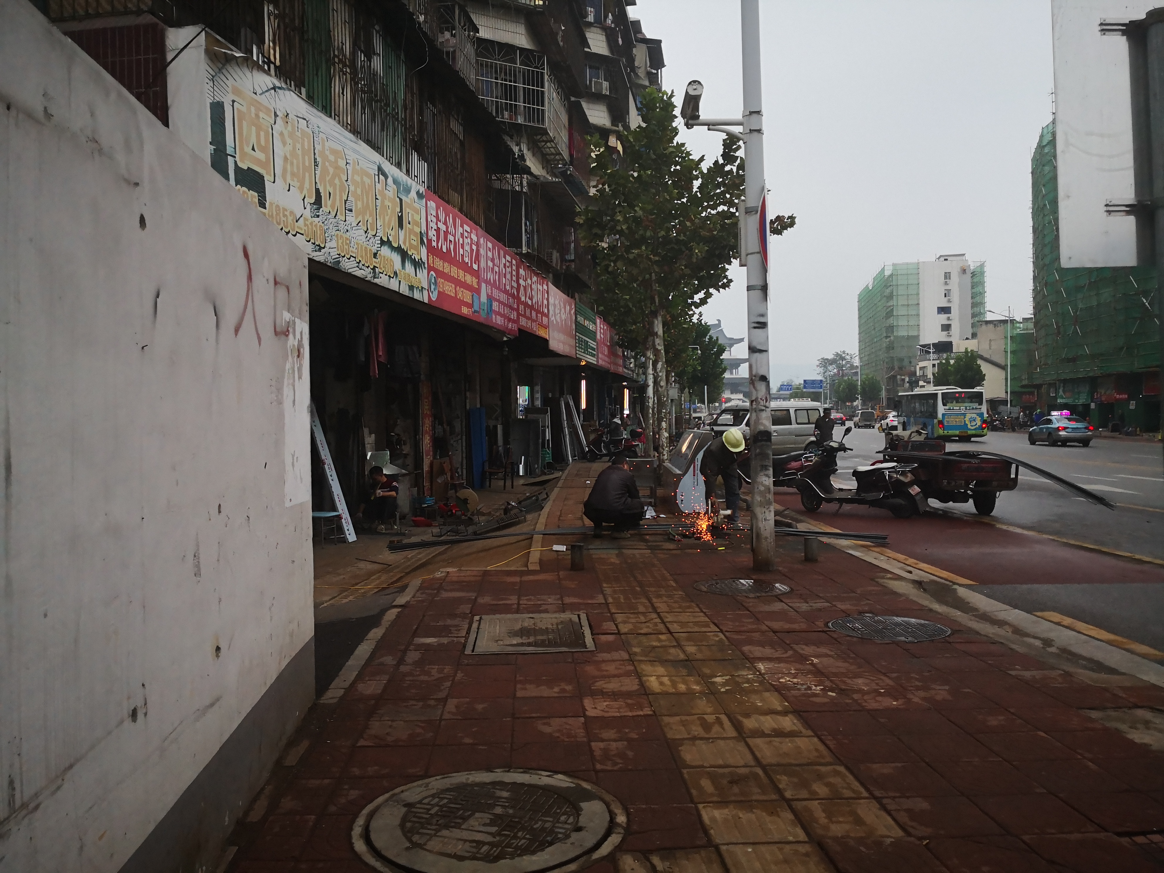 西湖路上多家经营户占道加工、堆放货物。