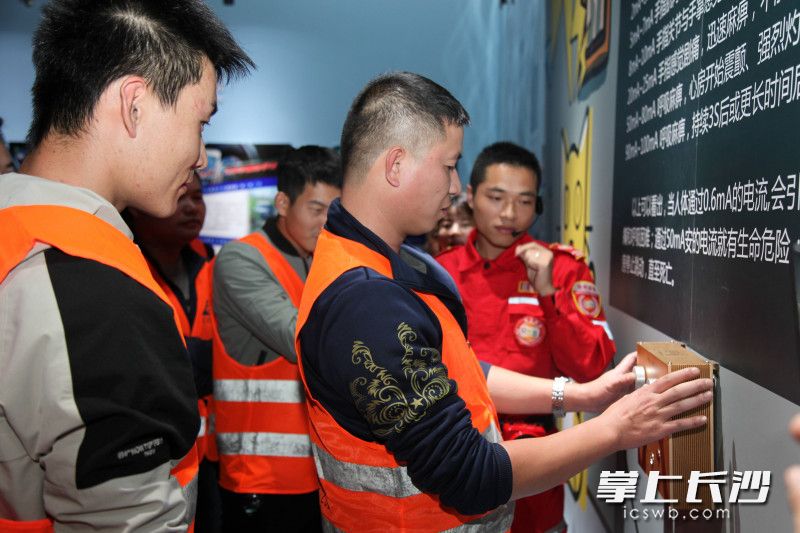 物业工作人员在指引下进行触电实验。
