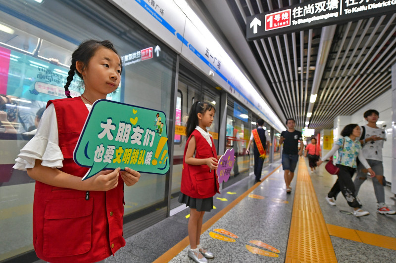 长沙地铁五一广场站内，身穿红色志愿者马甲的萌娃在地铁工作人员的带领下一同维护车站文明秩序，引来乘客纷纷点赞。 长沙晚报全媒体记者 王志伟 摄