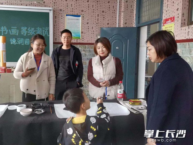 考前工作人员与考生交流。