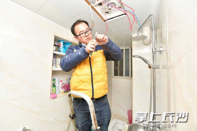 工作人员正在给邓娭毑家厕所做最后的安装。