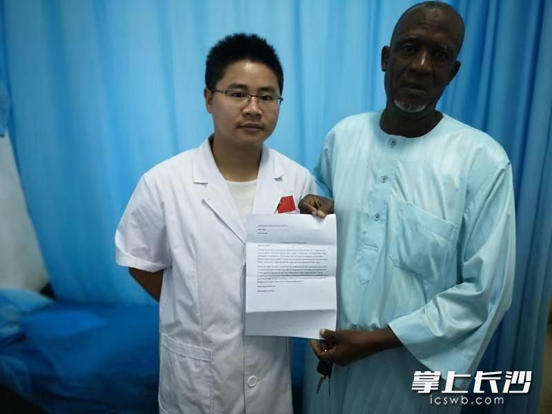 当地患者穆罕迈德（右）给周伟医生送来感谢信。